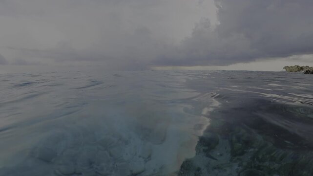 POV Swimmer in Turquoise Blue Ocean with Distant Storm Thunder