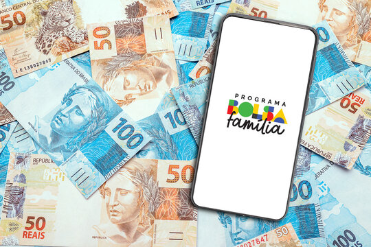 Rio de Janeiro, Brazil - January 14, 2026, Smartphone displays the Bolsa Fam&iacute;lia Program logo on Brazilian real banknotes.