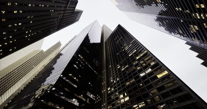 Towering skyscrapers dominate the skyline, reaching upwards as low clouds loom above. The architectural designs reflect a blend of modernity and tradition in the city.