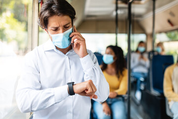 Hurry up. Portrait of responsible man in medical mask having important call speaking by smart phone...