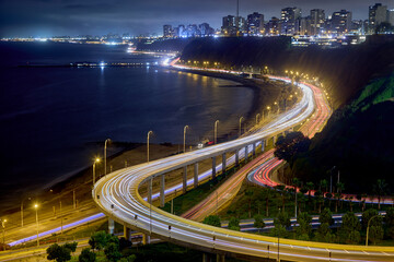 long-exposure photograph captures the dramatic curves of the Costa Verde (Green Coast) highway as it winds along the base of the cliffs in Miraflores, Lima, Peru. 