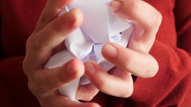 close-up video human hands crushing blank white paper. minimal and abstract composition represents failure, doubt, transformation. Ideal for creative process visuals, problem solving concepts
