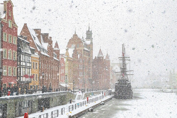 Beautiful ancient sail ship moored on the embankment of frozen Motlawa river in Gdansk	