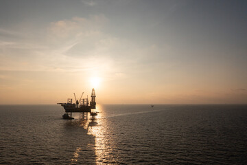 Obraz premium Aerial view of offshore jack up rig in a shipyard during sunset for oil and gas exploration and production.