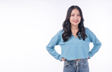 Confident young Asian woman standing with hands on hips and smiling. Beautiful happy female model...