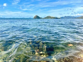 Crystal clear turquoise ocean water with distant tropical islands in the Philippines