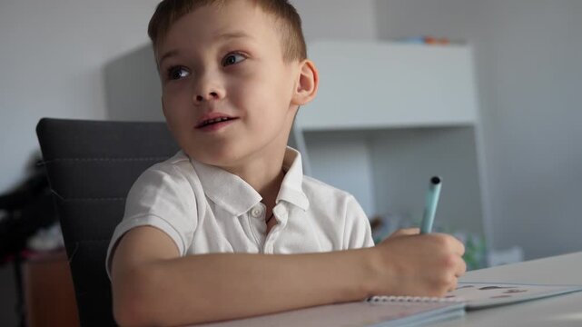 Young school-age boy does his homework and does his homework.