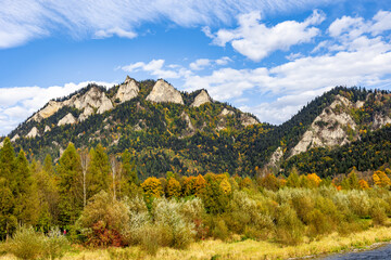 Scenic autumn mountain landscape with Trzy Korony peak and colorful forest in the Pieniny Mountains, Poland. Beautiful nature view under blue sky with clouds. © Ronin