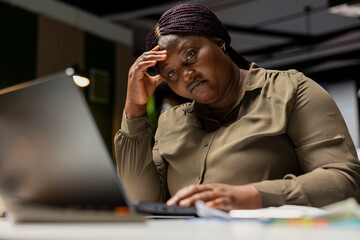 Female entrepreneur sighing being drained and overwhelmed after hours, pushing limits despite clear signs of fatigue and tension. Workplace challenges and discouragement bring discomfort.
