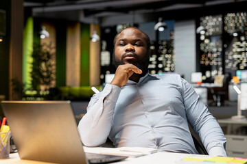 Business director reflects on a problem late at night after hours, methodical planning and creative contemplation to guide him toward a decision that balances rationality with positivity.