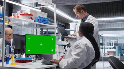 Chroma key display on monitor next to diverse experts in chemistry lab, using laboratory analysis for bioengineering and healthcare technology. Progress in pharmaceutical science.