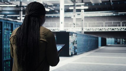 Developer doing data center automation using AI neural networks on tablet. Server room IT...