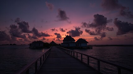 Tranquil sunset scene over water featuring structures and footbridge