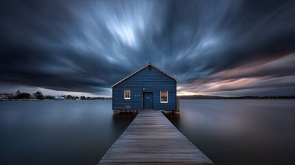 Tranquil lake house scene under dramatic cloudy sky with wooden pier