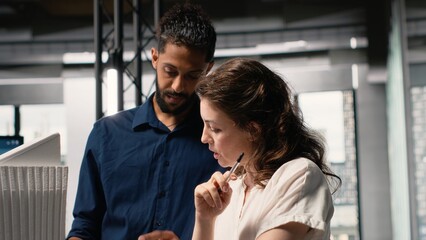 Diverse real estate team creating the layout for a residential area, simulating site preparation with 3D models before the project approval. Modern infrastructure city planning.