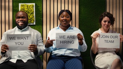 Business HR team shares hiring announcement on printed signs, motivating potential candidates to submit applications and explore open roles in the organization. Available position. Camera A.