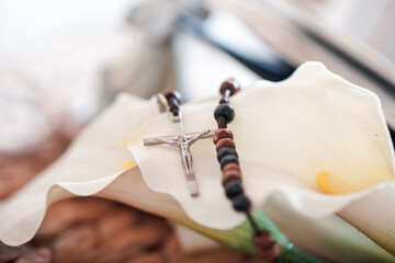 Rosary placed on a calla lily flower inside a room