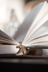 Open Catholic Bible rests on table with cross