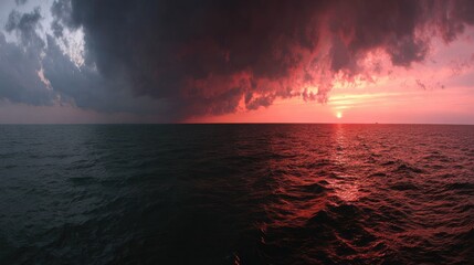 Dramatic split sky featuring ominous storm clouds meeting vibrant sunset over vast water expanse