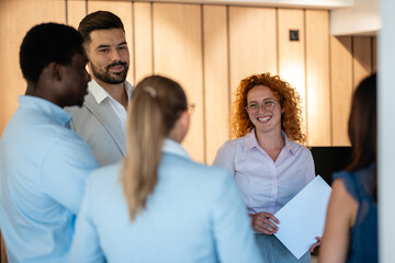 Group of diverse business professionals having casual conversation in office