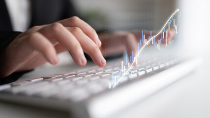 A businessperson types on a keyboard while engaging in market analysis. Graphical data overlays represent financial growth and trends in a modern workspace. Impute