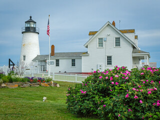 Pemaquid Point Lighthouse in Bristol ME on an early summer day in June with fresh flowers and lush foliage