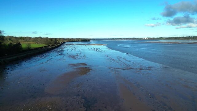 River Exe, Devon, England: DRONE VIEWS: The drone flies low over two boat wrecks exposed on the River Exe mudflats by low tide. The river is 60 miles long and a popular UK tourist destination (Clip 1)