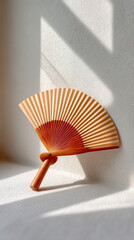 Bamboo fan with moving shadow lines on wall in sunlight
