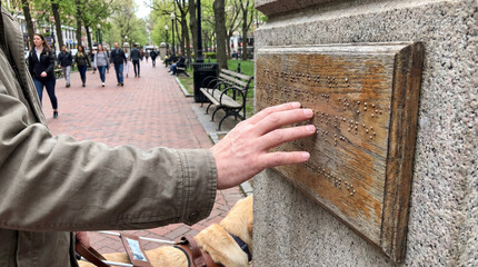 World Braille Day hand reading wooden sign accessibility public space inclusion outdoor wayfinding magazine editorial documentary photography