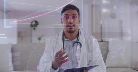 Sitting male doctor wearing white lab coat gesturing at home with stethoscope, tablet, holograms