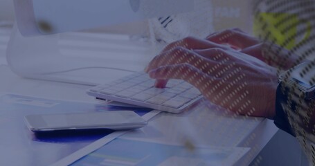 Typing right hand on white keyboard at desk, smartphone on blue charts, watch patterned sleeve