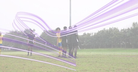 Forming wall, players standing on pitch under purple overlay, wearing yellow jersey and dark kits