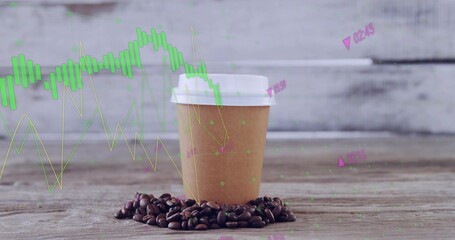 Sitting brown cup with white lid on wooden tabletop, ringed by coffee beans and financial graphs