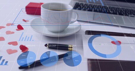 Sitting white ceramic coffee cup on saucer at white desktop, showing pen, heart confetti, charts