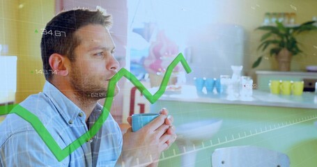 Holding turquoise mug, man in blue shirt studying green rising graph at kitchen counter, copy space