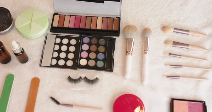 When camera is panning right, makeup palette and brushes are being revealed to showcase flat lay