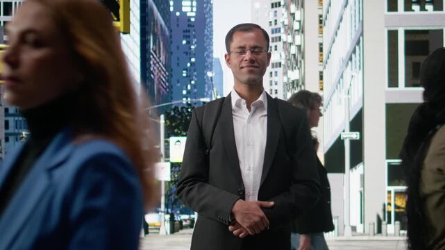 Timelapse portrait of indian businessman standing on busy street downtown among pedestrian group of different ages during morning commute. Diversity and the rhythm of everyday urban life.