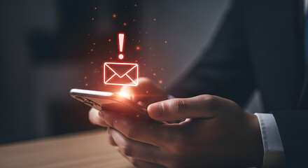 Person holding smartphone with glowing email notification and exclamation mark indicating important message received