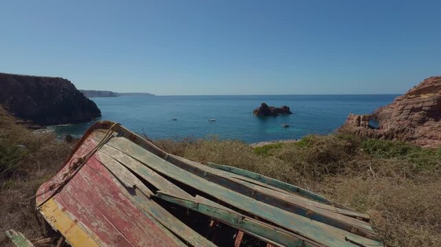 Wrecked fishing boat Algarve coast Portugal blue Atlantic sea
