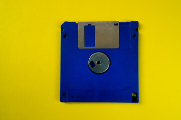 Vintage blue 3.5-inch floppy disk on vibrant yellow background