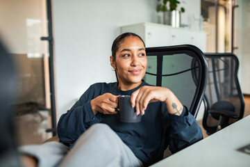 Young entrepreneur enjoying coffee break in startup office