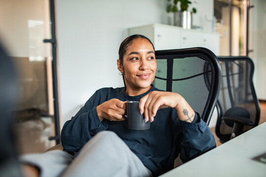 Young entrepreneur enjoying coffee break in startup office