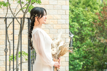 Obraz premium Wedding venue, dried flowers in the chapel, bride in a dress holding a swag, bride