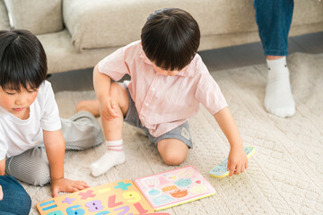 Fototapeta premium Family playing in the living room of their own home, parent and child (childcare, child rearing)