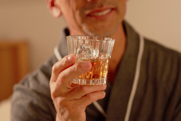 男性が持っているウィスキーの手元のクローズアップ