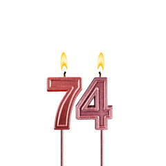Lit birthday candle - Candle number 74 on white background