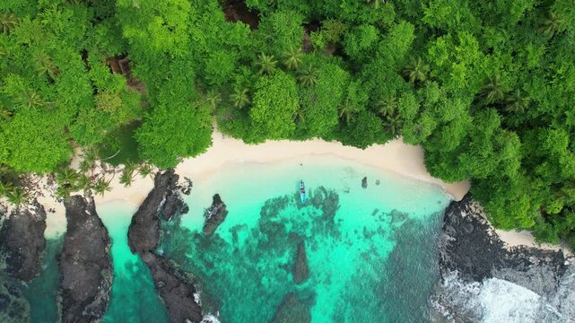 Seen from above the turquoise sea and a boat leaving the Caf&eacute; beach in Ilheu das Rolas in S&atilde;o Tom&eacute;,Africa