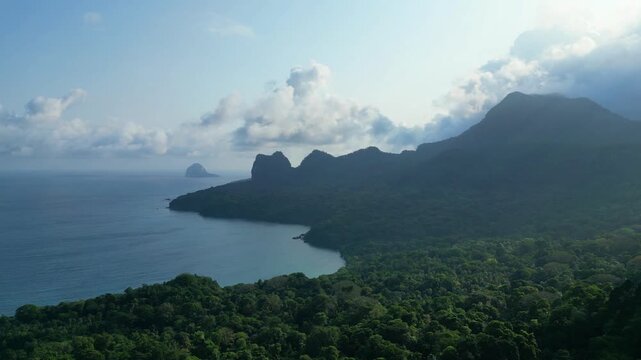 Aerial view over the biosphere forest with the Jockey hat at background at Prince Island,Sao Tome,Africa. Circular drone shot
