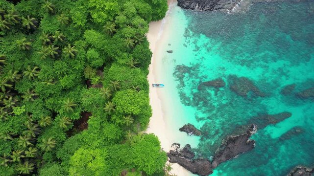 A Static view from the beuatifull turquoise sea from caf&eacute; beach with a anchored boat at Ilheu das Rolas,S&atilde;o Tom&eacute;,Africa