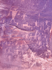 A wall with many drawings of people and animals. The mood of the painting is mysterious and intriguing, as the drawings seem to be of people and animals that are not real